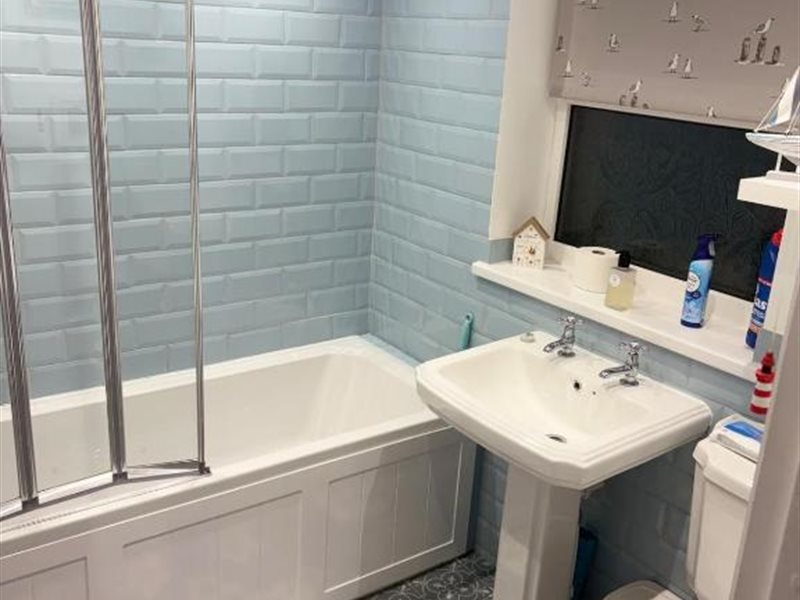 Modern bathroom with blue tile, bath and shower