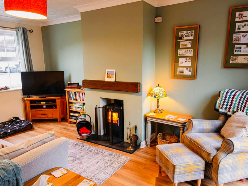 Warm cosy lounge at Chapel Bricks with log burner and comfortable seating