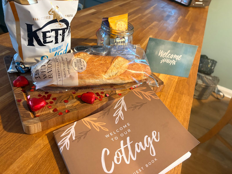 Cottage welcome pack with fresh bread, jams, biscuits and guest book